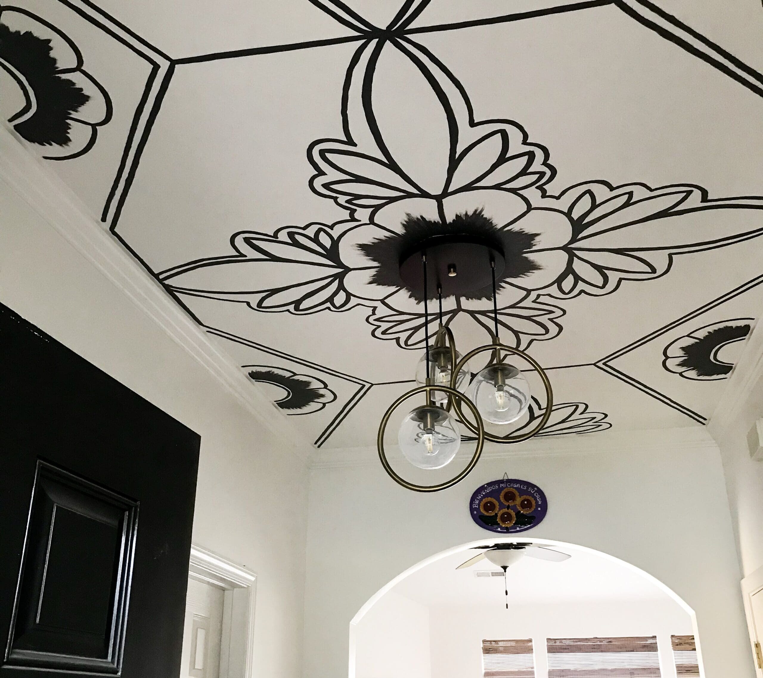 Hand-painted ceiling with bold floral and geometric design in a home entryway